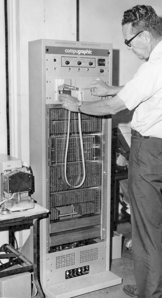 A man stands next to a large computer.