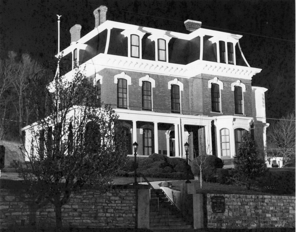 Victorian house lit up at night.