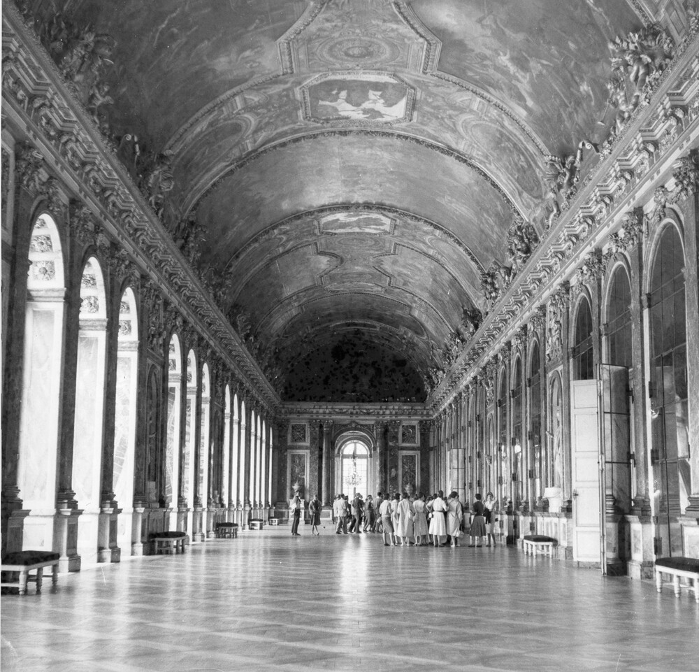 Tourists in a large hallway of mirrors.