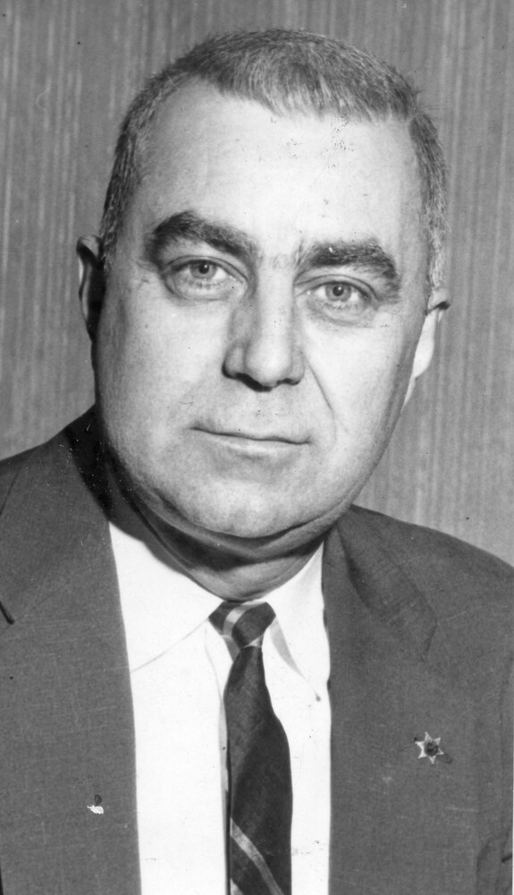 Head shot of man with crew cut, wearing a suit
