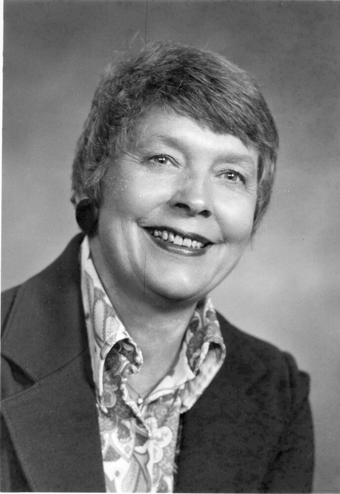 Head shot of smiling woman with short hair, wearing blouse and jacket