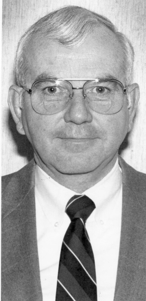 Head shot of man, wearing glasses and suit and tie