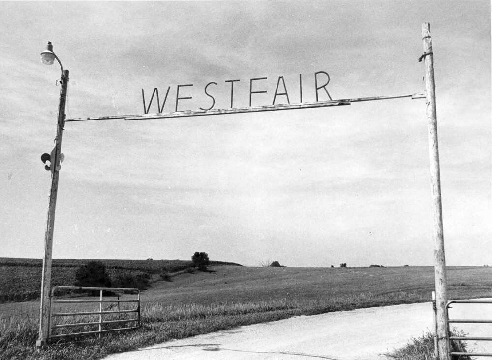Sign over gate, on crossbar above road