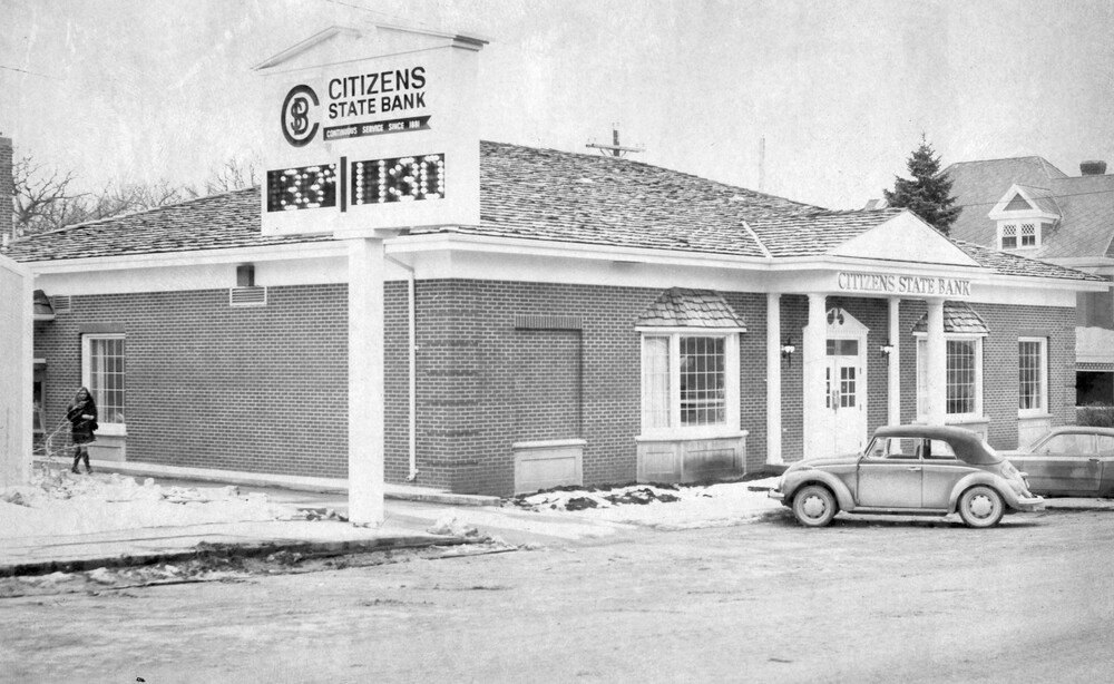 A brick building with a large sign beside it.
