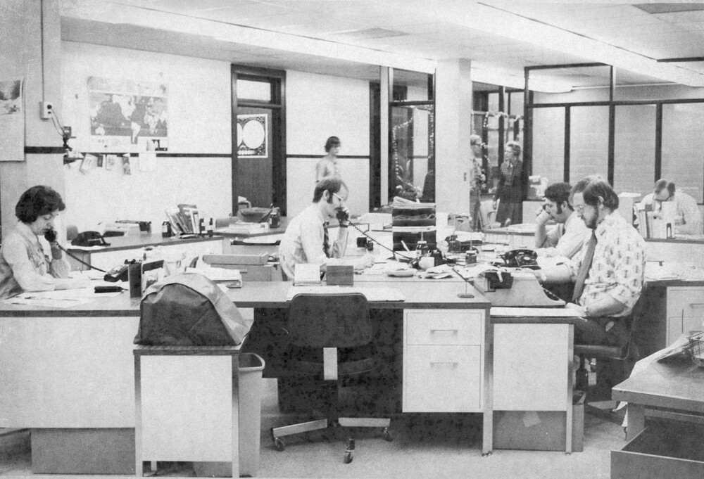 A group of men sitting at desks.