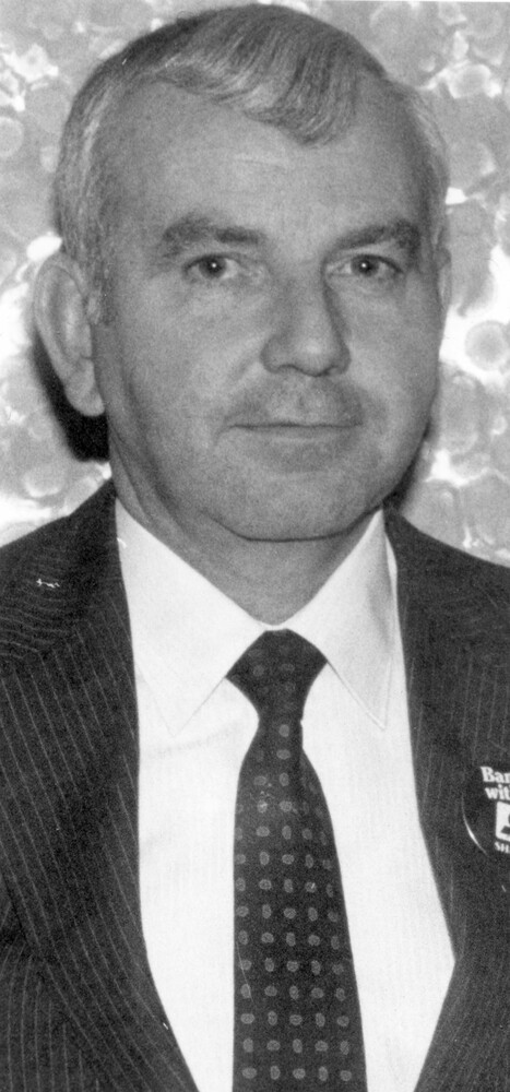 Headshot photo of man in suit and tie