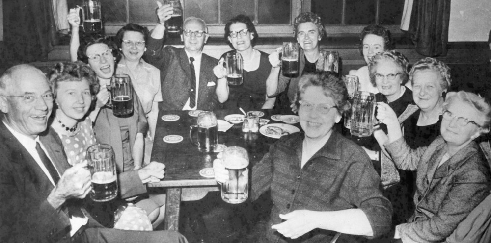 A group of people holding up beer steins. 