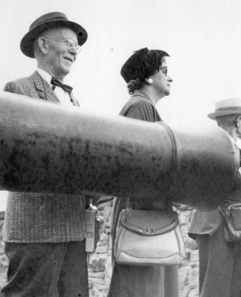 Two people standing behind a cannon.