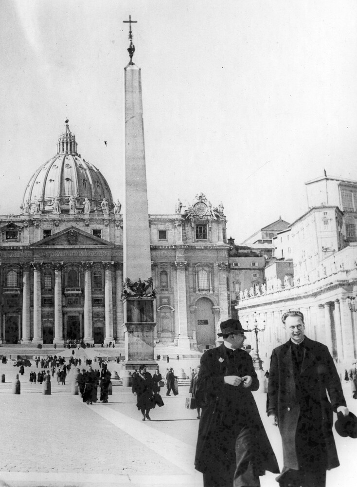 Many people walking in front of St. Peter's Basilica. 