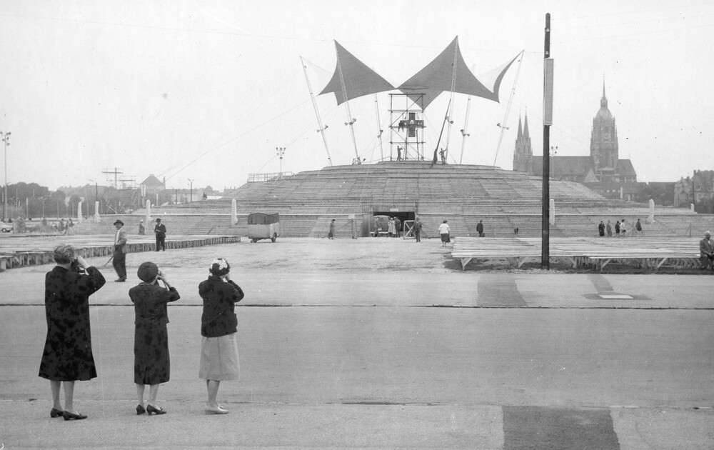 Three women photographing an altar in a park.