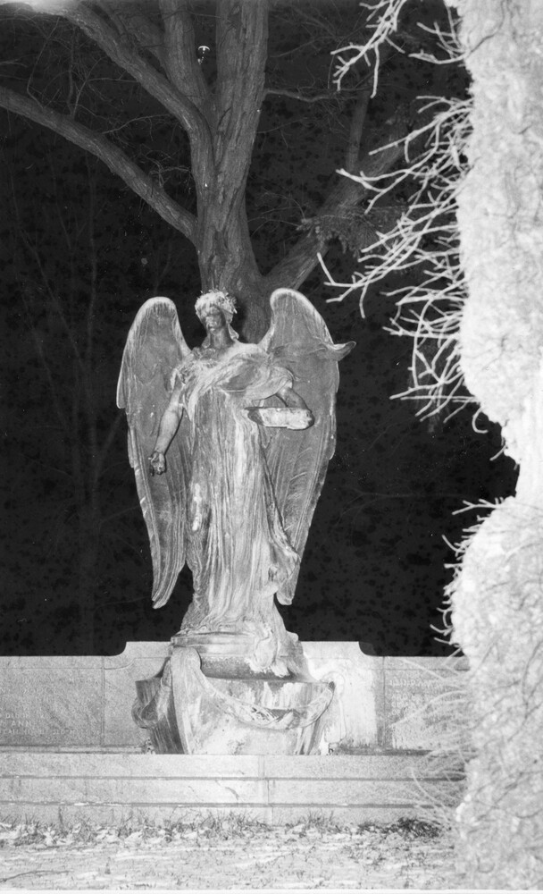 large outdoor state of an angel, lighted against a night sky