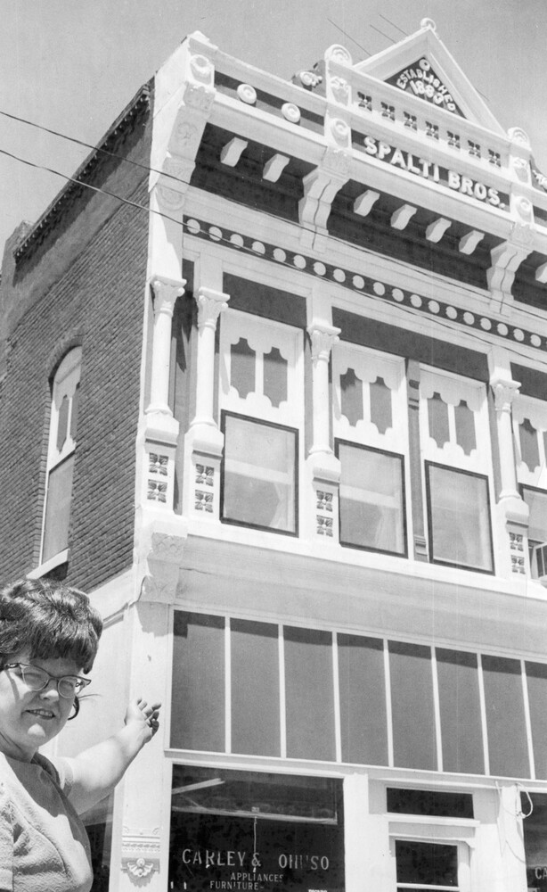 A woman pointing to an ornate building.