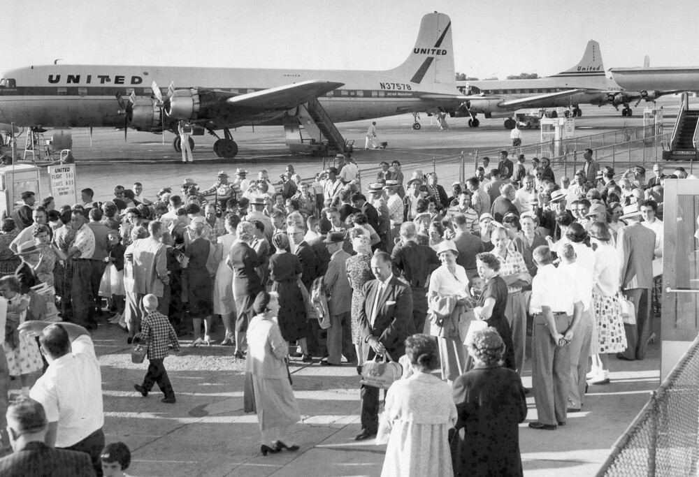 Crowd of people near a plane.