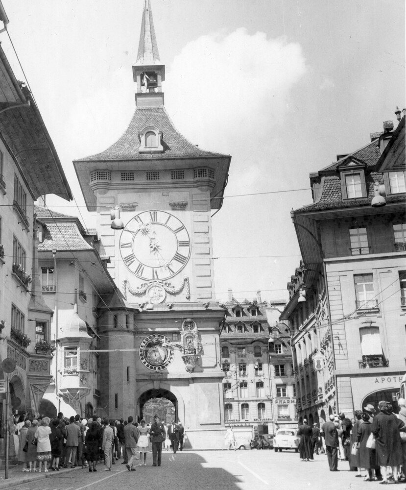 A clocktower on a city street.