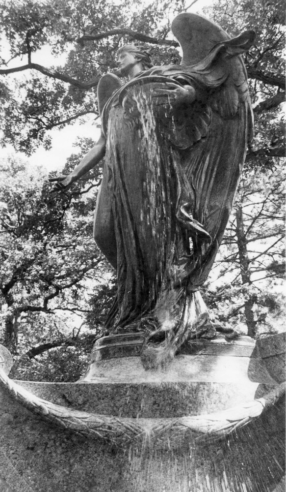 large outdoor state/fountain of an angel, viewed from below.