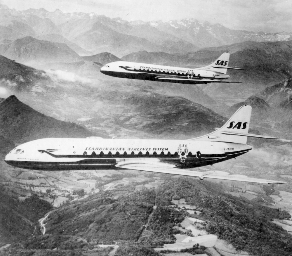 Two jets flying over mountains.