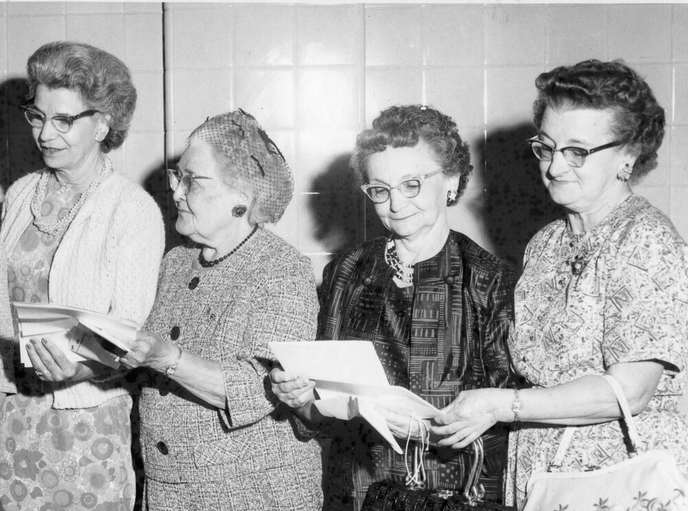 Four women looking at paperwork.