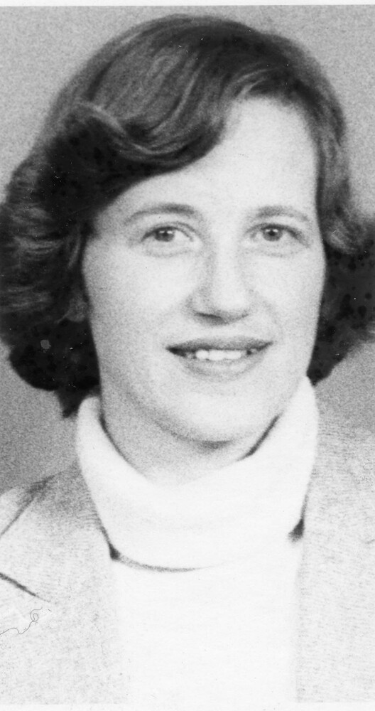 Head shot of woman with short, dark hair, wearing turtleneck sweater and jacket.