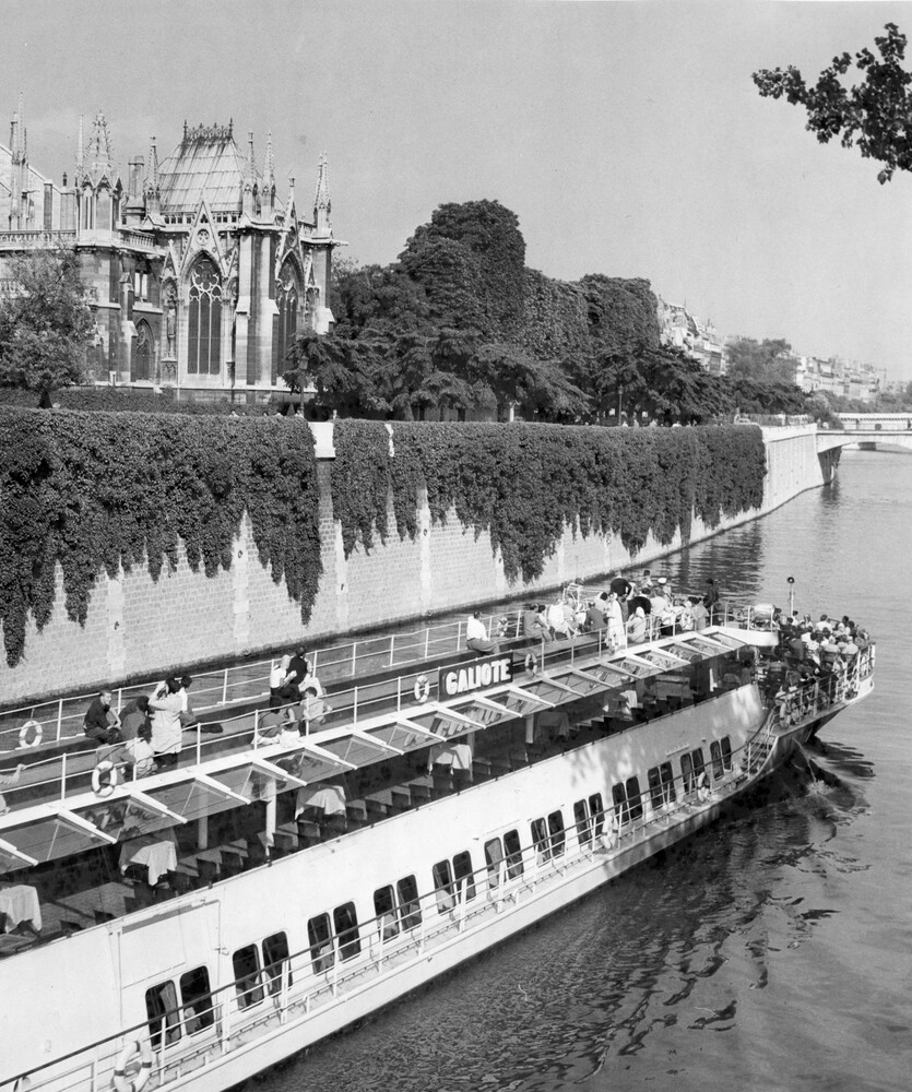 A boat on a river with a cathedral in the background.
