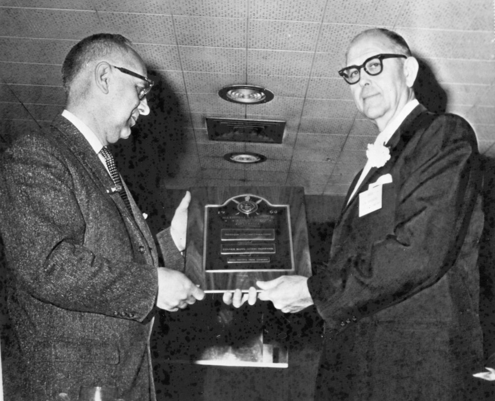 Two men holding an award plaque.