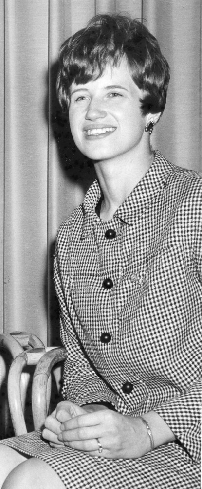 Photo of seated young woman in a houndstooth suit