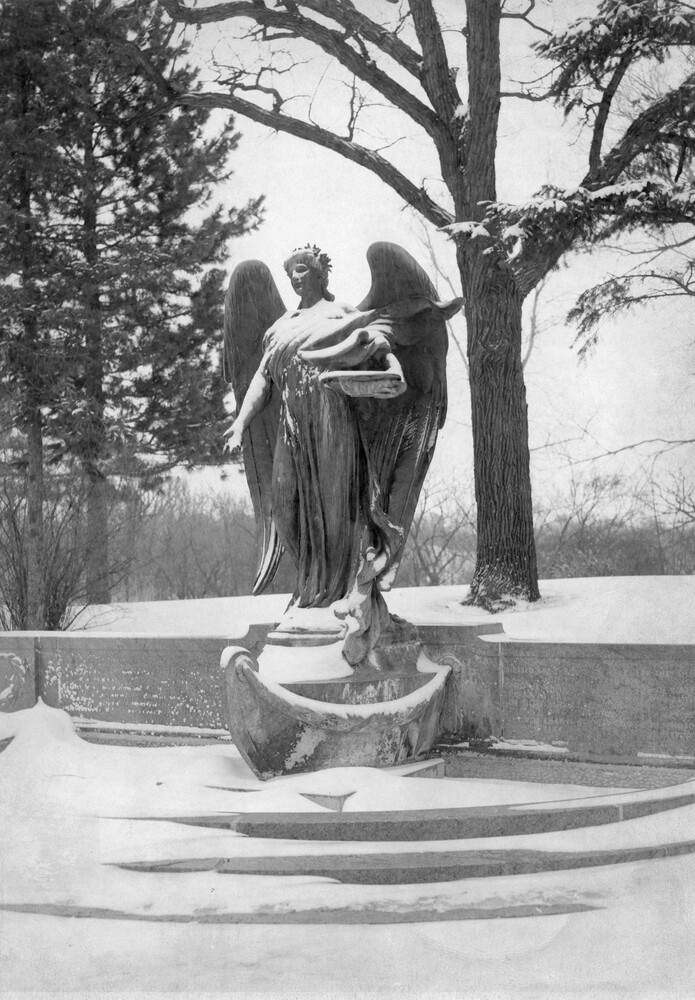 large outdoor statue/fountain of an angel, in winter landscape