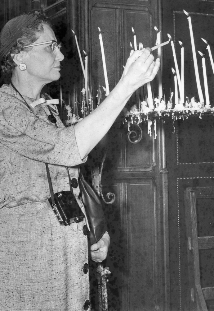 A woman lighting a candle.