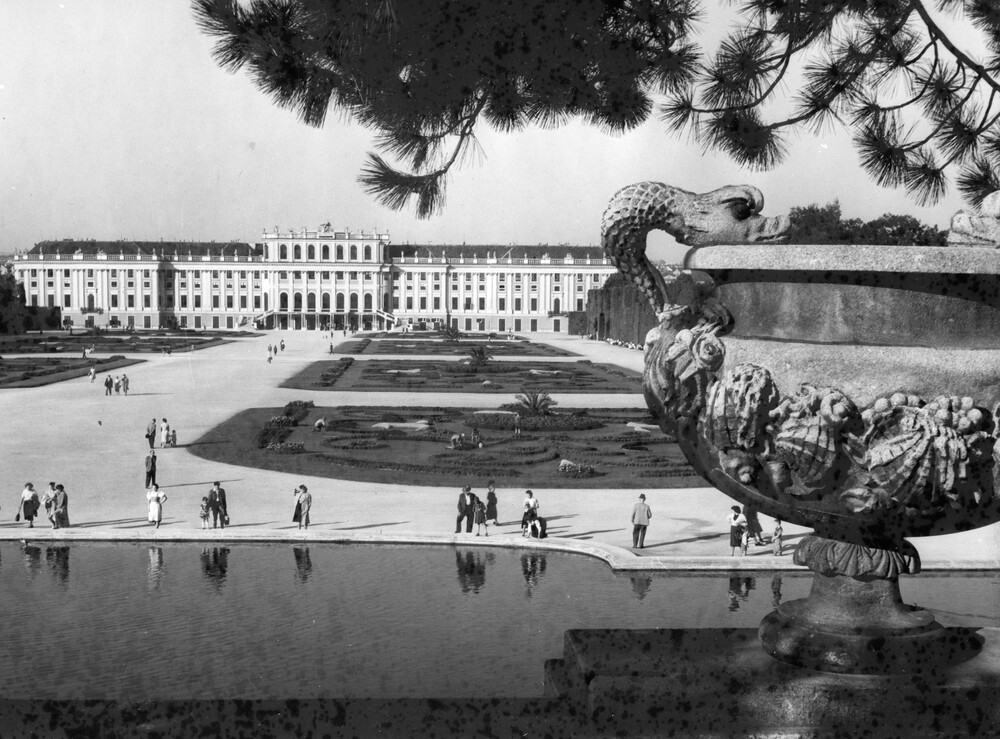 Tourists strolling the grounds in front of a palace.