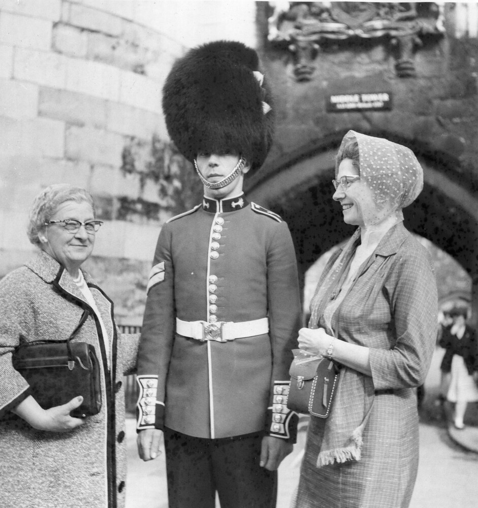 Two women smiling at a guard.