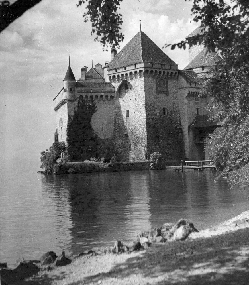 A castle at the edge of a lake.