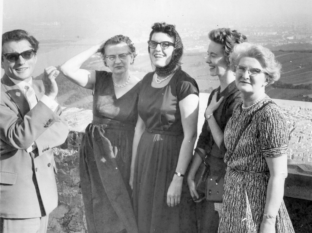 A man and four women on an overlook.
