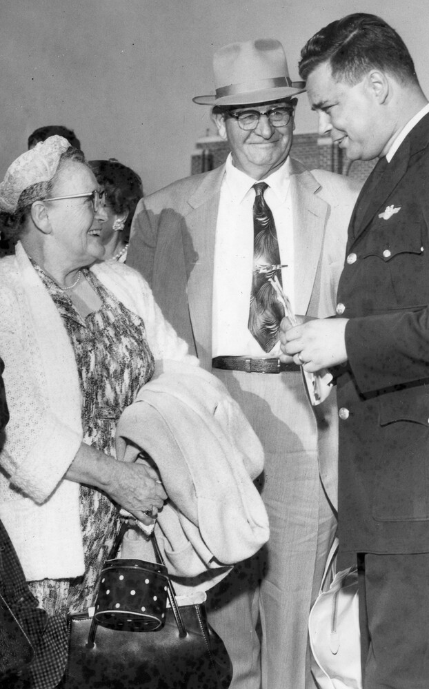 A woman smiling at two men.