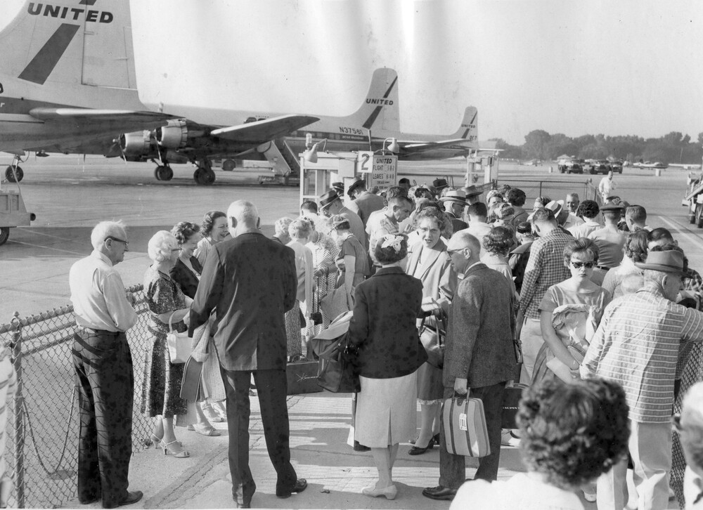 A crowd gathered at an airport gate.