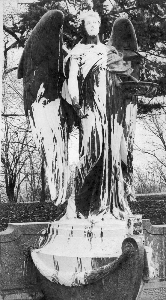 large outdoor statue of an angel splashed with white paint