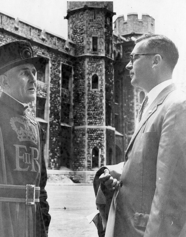 Two men in front of a towered building.