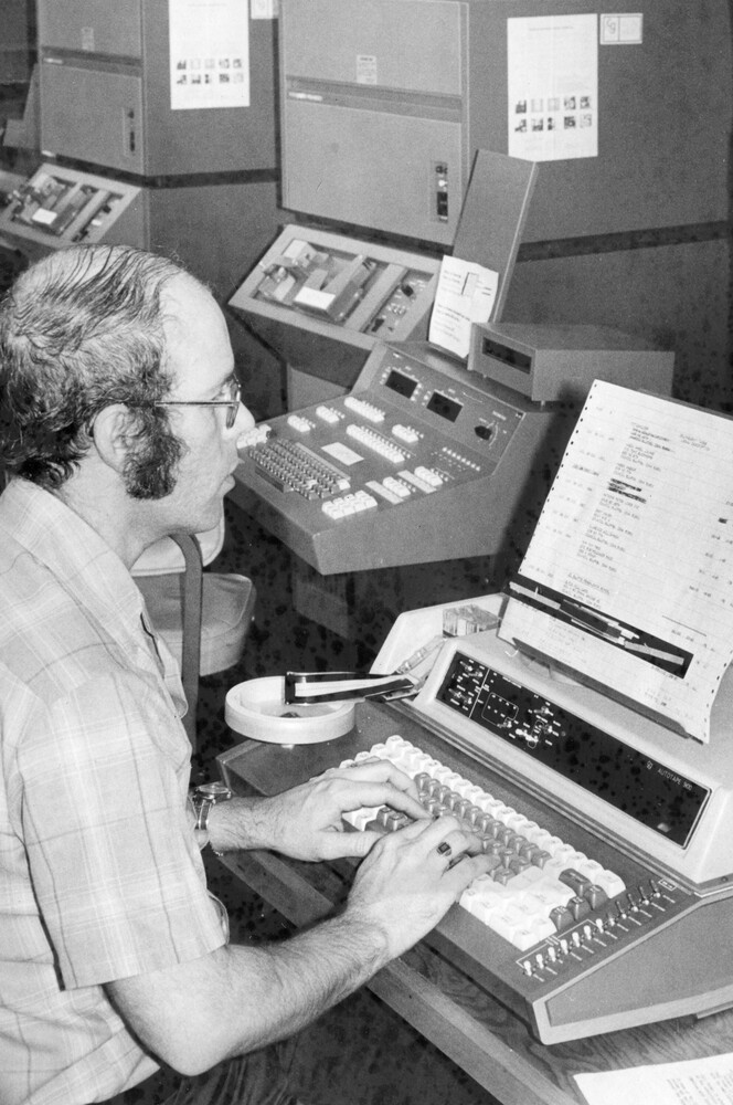 A man sitting at a typesetter.