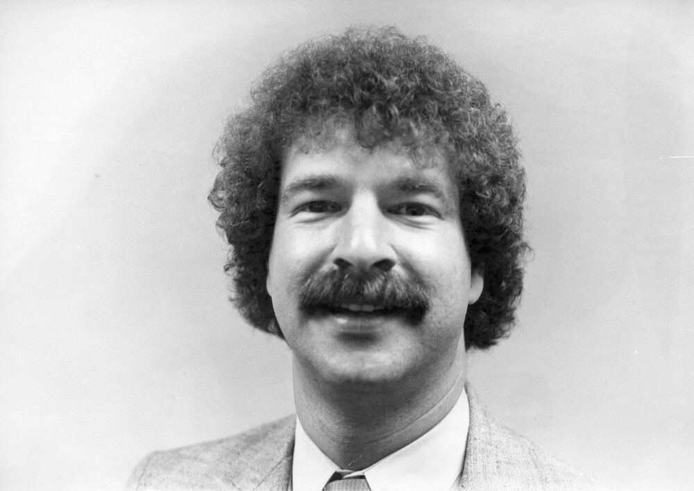 head shot of man with moustache