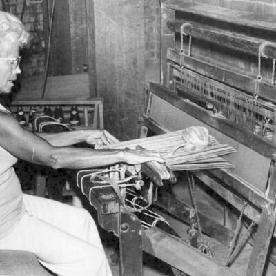 A woman sitting at a loom.