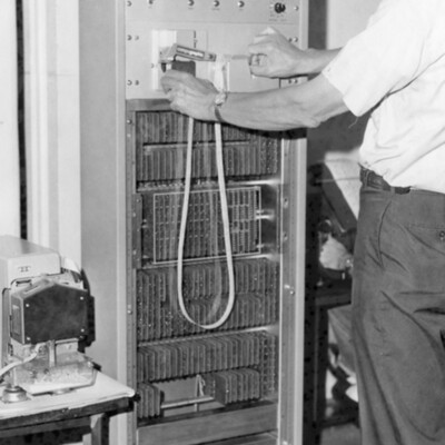 A man stands next to a large computer.