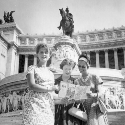 Three women in front of a monument.