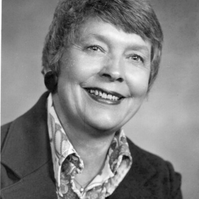 Head shot of smiling woman with short hair, wearing blouse and jacket