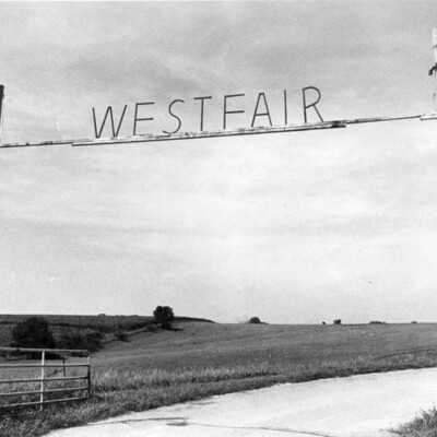 Sign over gate, on crossbar above road