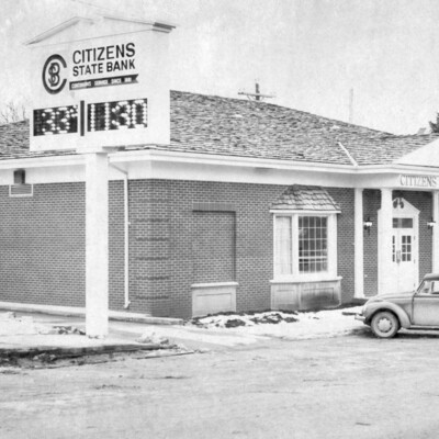 A brick building with a large sign beside it.
