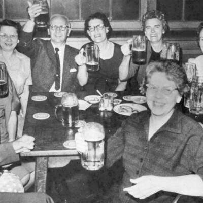 A group of people holding up beer steins. 