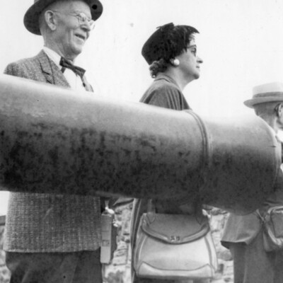 Two people standing behind a cannon.