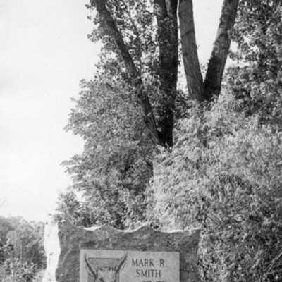 Photo of stone marker, in a wooded area, indicating a wildlife refuge