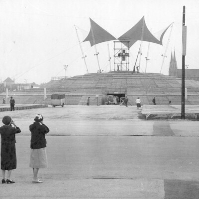 Three women photographing an altar in a park.