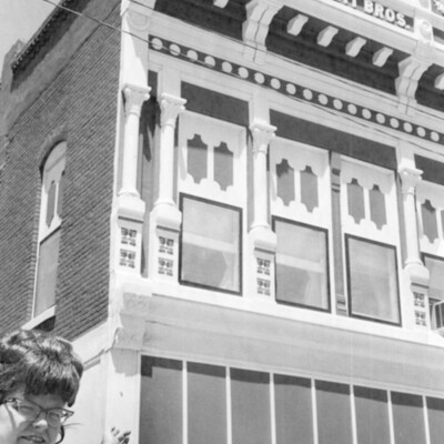 A woman pointing to an ornate building.