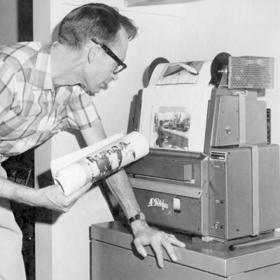 A man viewing a fax machine.