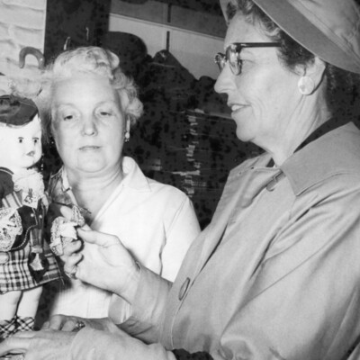 Two women viewing a doll.